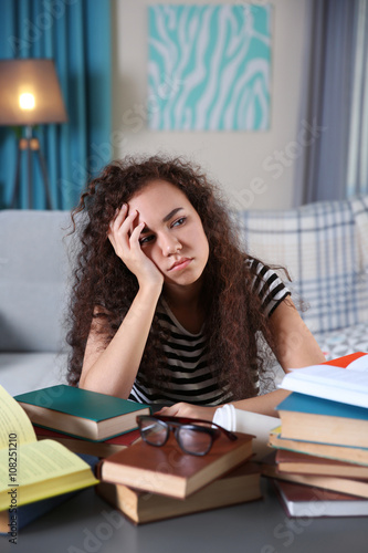 Tired student with books at...