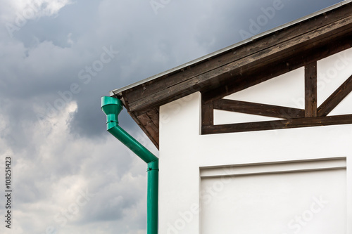 corner of house with green metal drainpipe