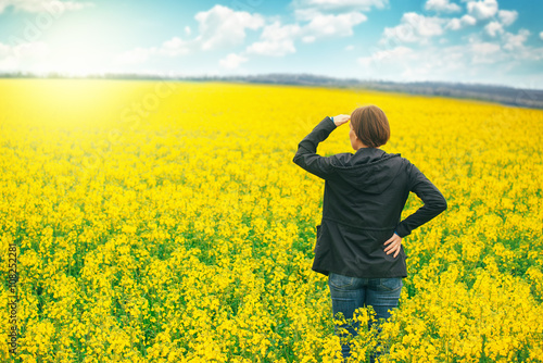 Woman agronomist standing in field of blooming cultivated rapese © Bits and Splits
