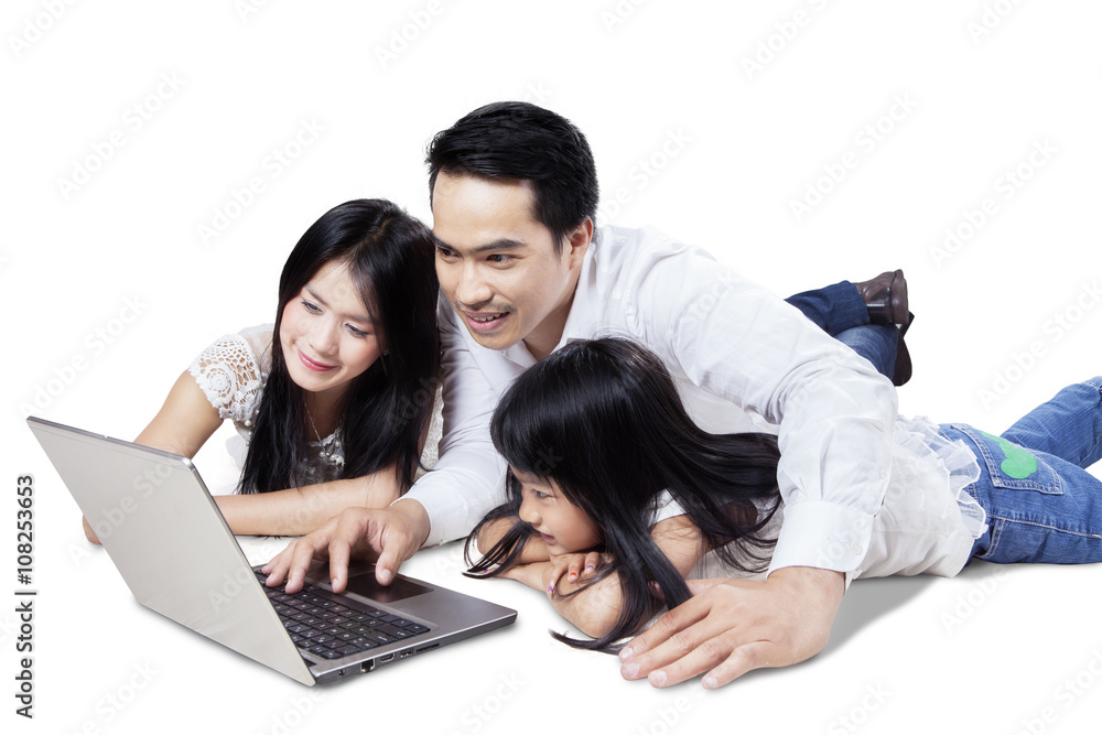 Cheerful family use notebook in studio Cheerful family use notebook in studio