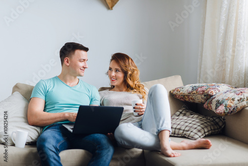 Shot of young couple discussing news using laptop computer