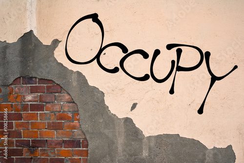 Handwritten graffiti Occupy sprayed on the wall, anarchist aesthetics 