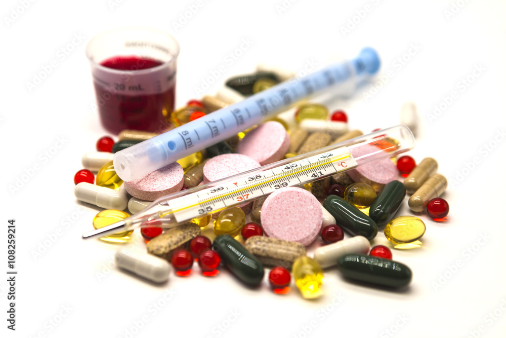 Different pills, medications with medicine with a syringe and with thermometer on white background closeup. Different pills, medications with medicine with a syringe and with thermometer on white background closeup.