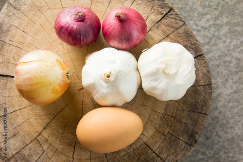 Raw garlic onion shallot egg on cutting board
