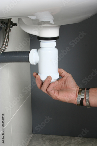 Plumber fixing the drain of a sink