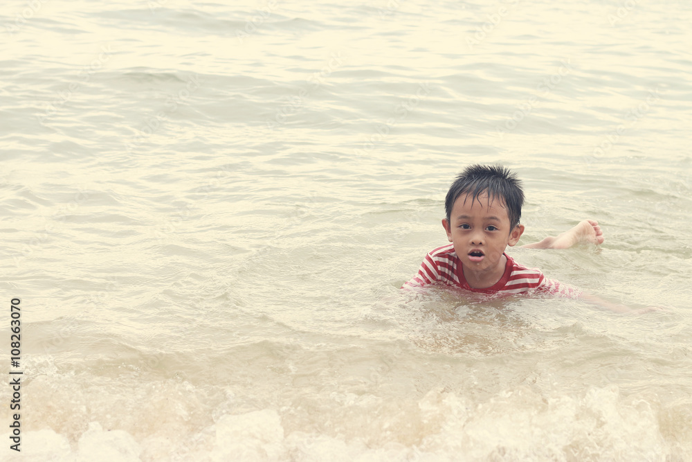 Asian kids were swimming in the sea playfully. Asian kids were swimming in the sea playfully.