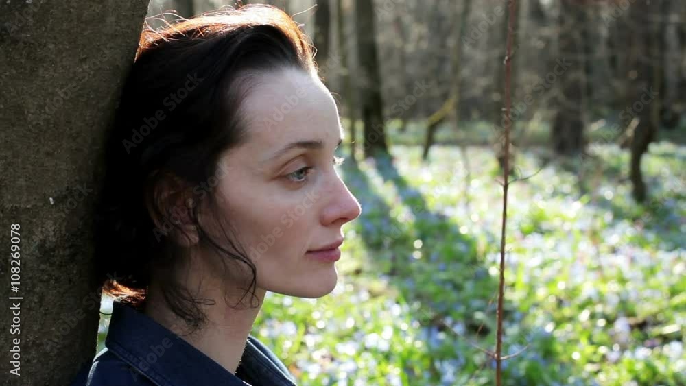 The young woman smelling the bouquet of the bluebells The young woman smelling the bouquet of the bluebells