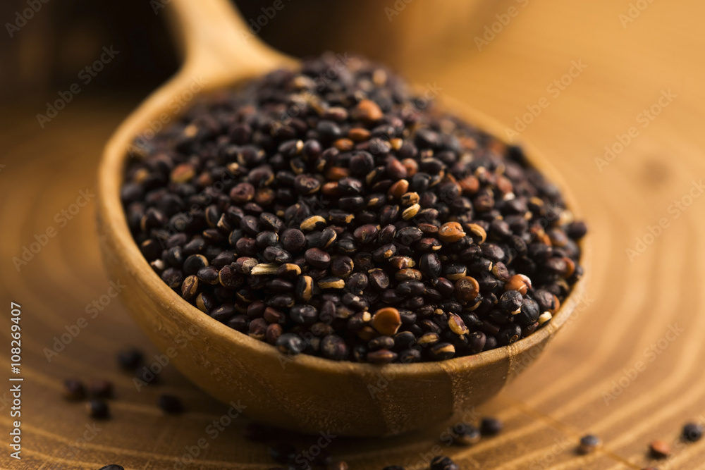 Black quinoa seeds on a wooden background Black quinoa seeds on a wooden background