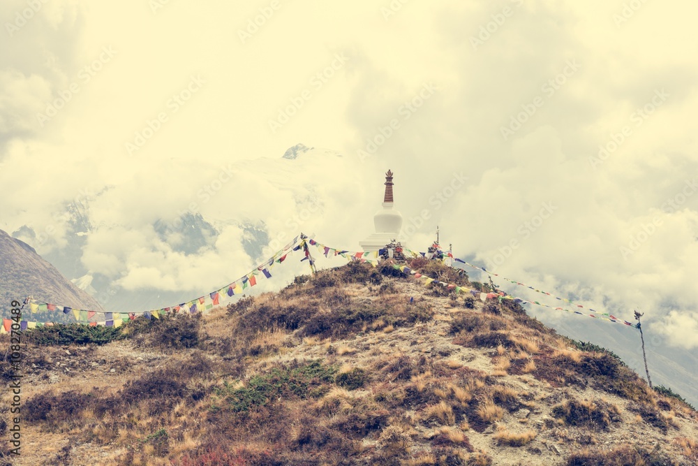 Praying flags with stupa on a mountain ridge.