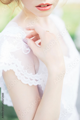 Close-up of bride in white laced dress