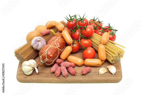 pasta, vegetables and sausages on a cutting board