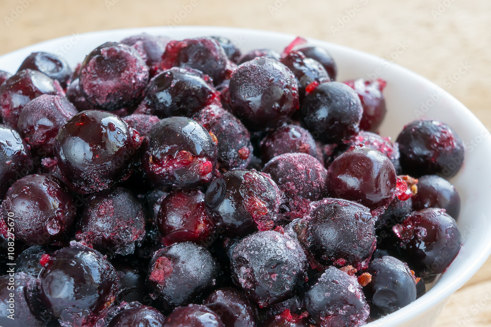 Frozen black currant in porcelain bowl. Defrosting fresh berries Frozen black currant in porcelain bowl. Defrosting fresh berries