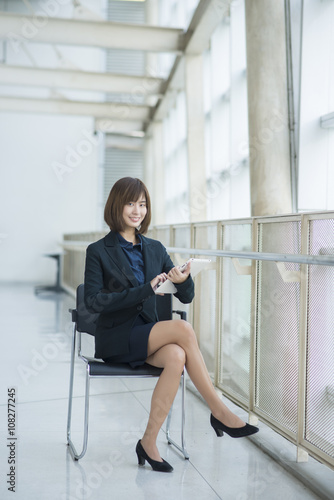 Attractive asian business woman working on tablet computer outsi