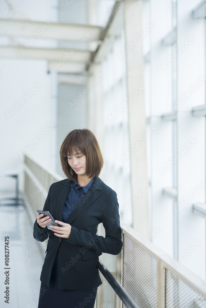 Attractive asian business woman using on smartphone outside Offi Attractive asian business woman using on smartphone outside Offi