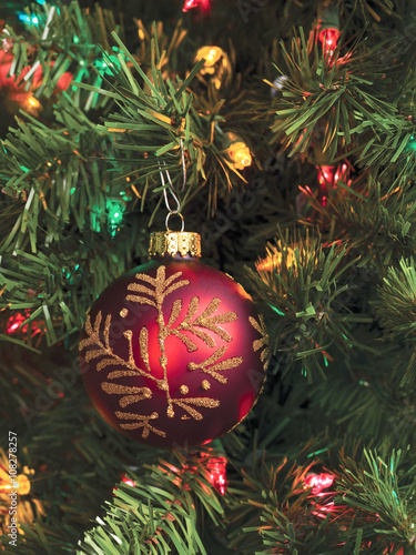 vertical image of christmas tree with bauble and lights.