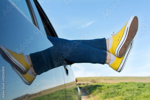 Fotografie Woman legs out of the car window