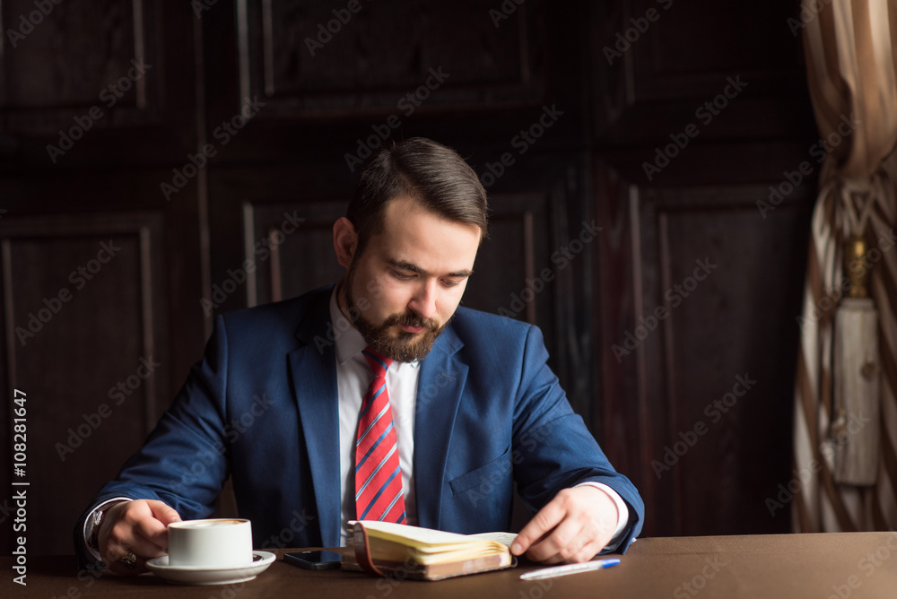 businessman or writer, making notes in his diary notebook businessman or writer, making notes in his diary notebook