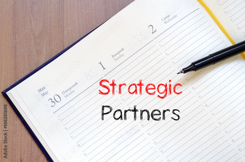 Strategic partners write on notebook