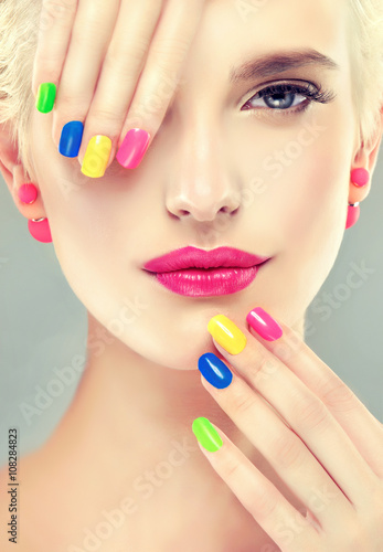 colorful makeup and manicure nails . Stylish blonde girl with bright makeup and colorful nail Polish on your nails . Spring and summer look and Earrings beads 