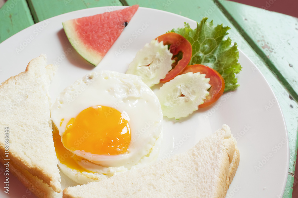 Fototapeta premium Close up fried egg with bread and vegetable with watermelon