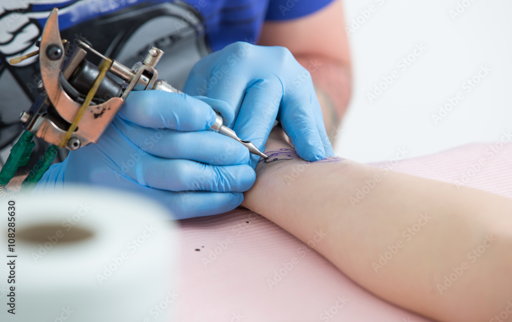 Tattoo artist at work close up