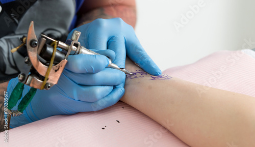 Tattoo artist at work close up
