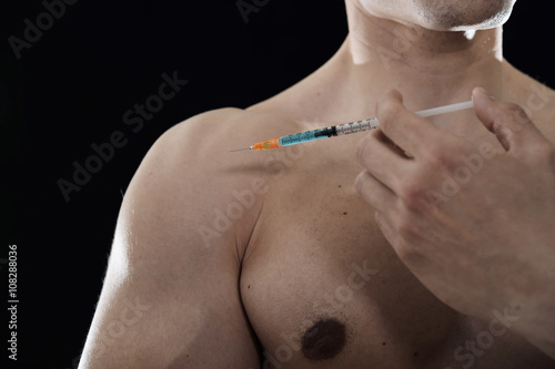 young body building sportsman using steroids for increasing sport and athletic performance injecting syringe shoulder