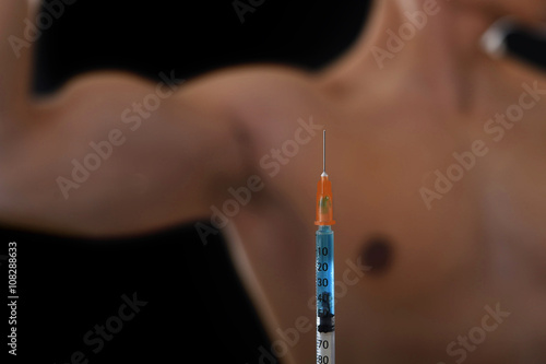 body building sportsman using steroids for increasing sport and athletic performance with close up syringe