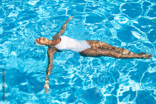 Plakat w ramie femme qui fait la planche dans l'eau avec un bonnet de bain