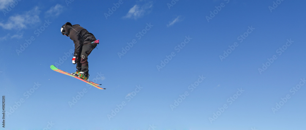 Skier doing high jump above the mountain Skier doing high jump above the mountain