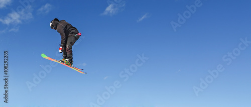 Skier doing high jump above the mountain