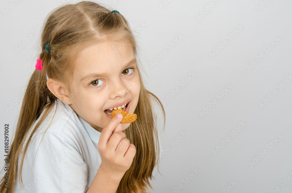 Portrait of a little six year old girl biting a cookie Portrait of a little six year old girl biting a cookie