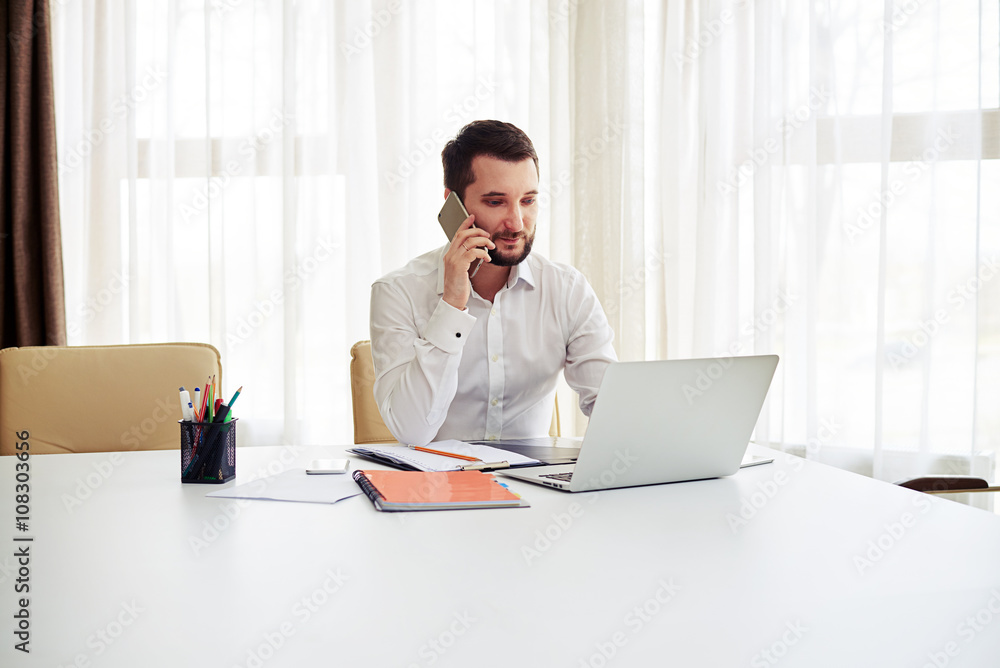 Man working and calling someone on the phone in the modern offic Man working and calling someone on the phone in the modern offic