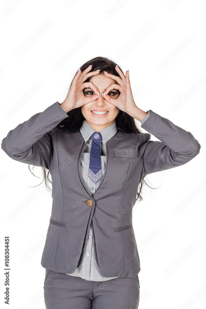 woman in gray suit holding fingers like glasses. human emotion expression and lifestyle concept. image on a white studio background. woman in gray suit holding fingers like glasses. human emotion expression and lifestyle concept. image on a white studio background.
