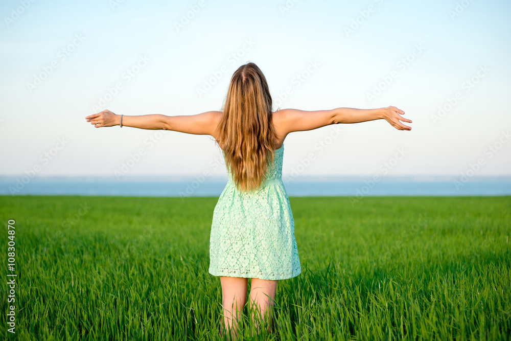 Happiness woman stay outdoor under sunlight of sunset. With raised hands at the sunrise time. Happiness woman stay outdoor under sunlight of sunset. With raised hands at the sunrise time.