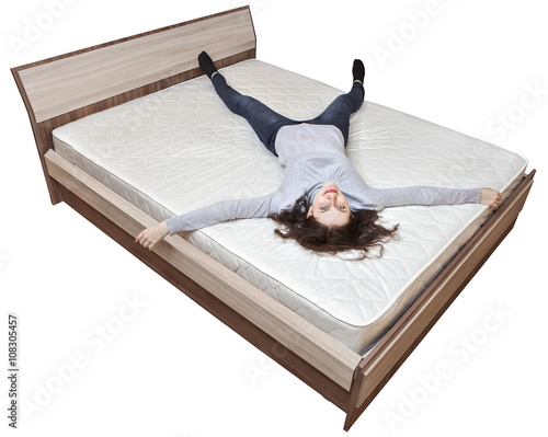 One young Caucasian girl is resting on bed innerspring mattress. photo