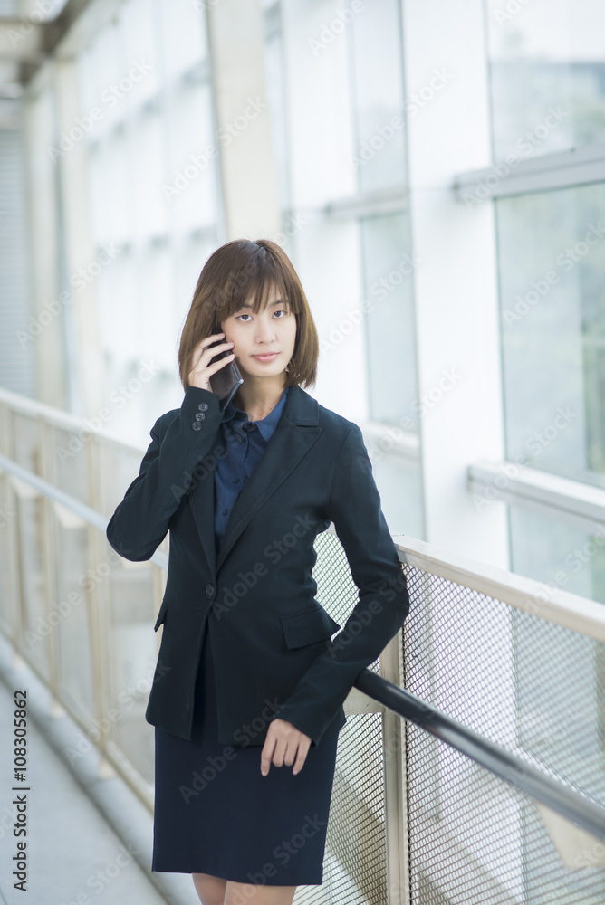 Attractive asian business woman using on smartphone outside Offi Attractive asian business woman using on smartphone outside Offi