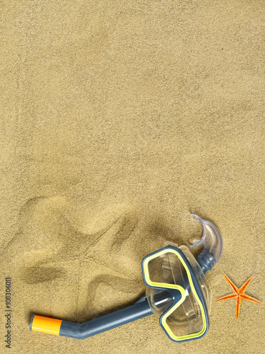 Starfishes and swimming goggles on sand