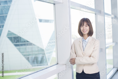 Attractive asian business woman smiling outside office