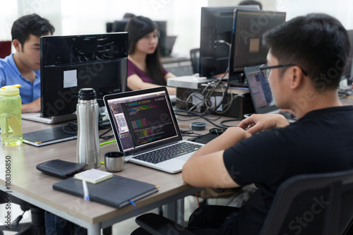 Asian Outsource Developer Team Sitting At Desk Working Laptop
