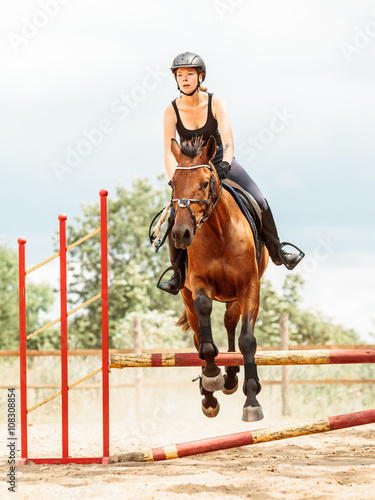 Woman jockey training riding horse. Sport activity © Voyagerix