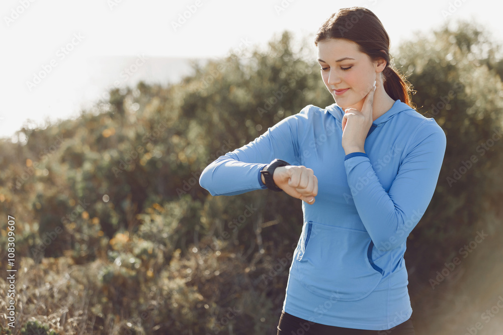 Runner woman with heart rate monitor running on beach Runner woman with heart rate monitor running on beach