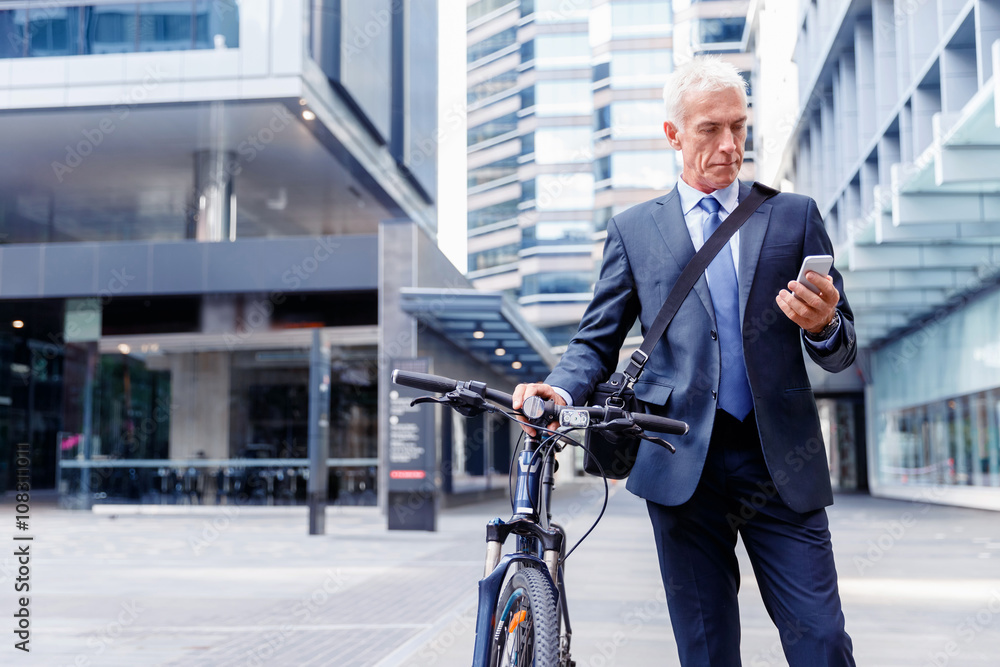Successful businessman on bicycle with mobile phone Successful businessman on bicycle with mobile phone