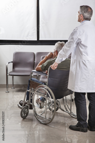 Doctor consulting with a patient in a wheelchair