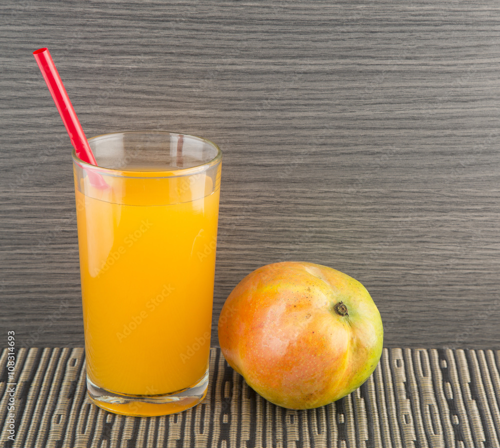 Mango juice and fresh mango on a dark wood background. tinting. selective focus Mango juice and fresh mango on a dark wood background. tinting. selective focus