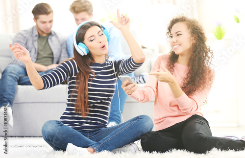 Two teenager girls listenin...