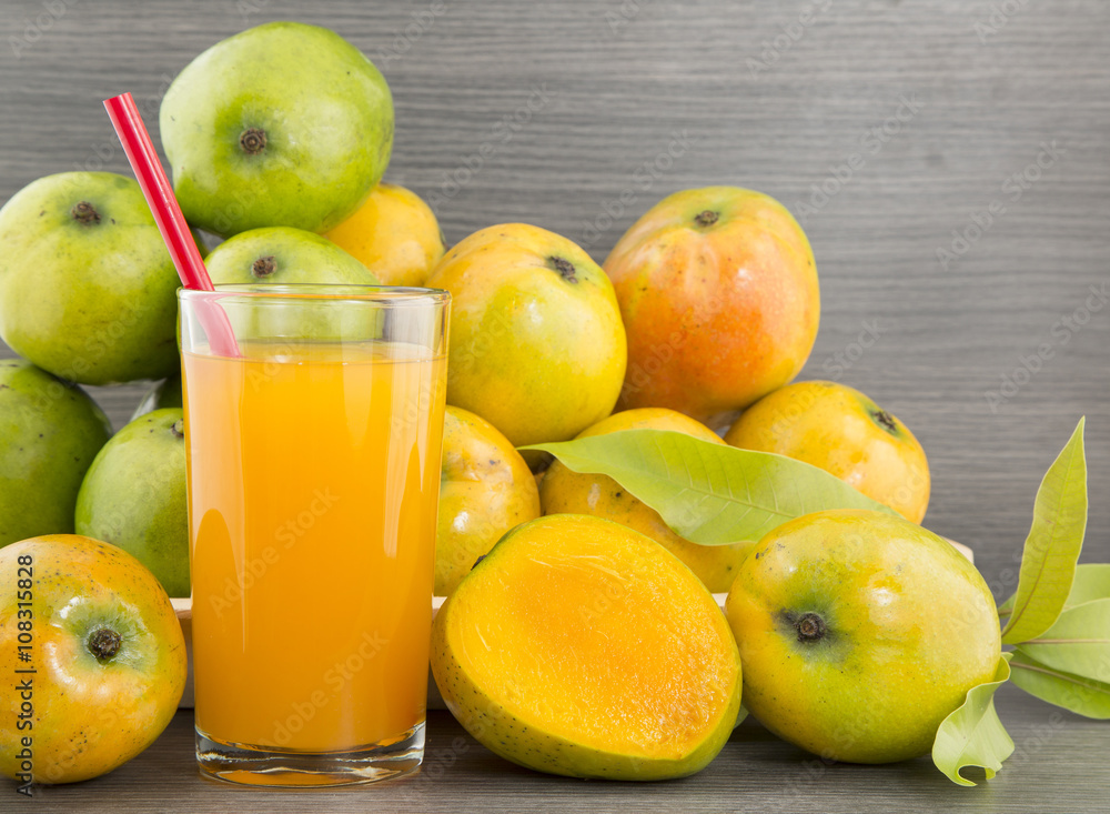Mango juice and fresh mango on a dark wood background. tinting. selective focus Mango juice and fresh mango on a dark wood background. tinting. selective focus