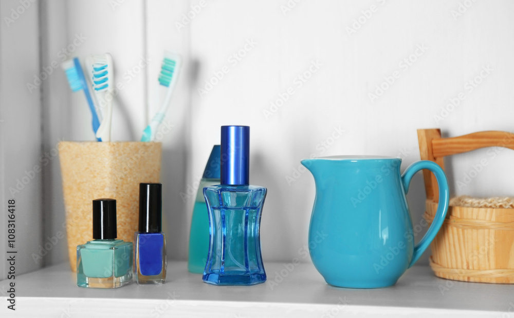 Bathroom set with toothbrushes and cosmetics on a shelf in light interior Bathroom set with toothbrushes and cosmetics on a shelf in light interior