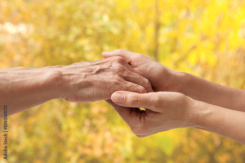 Hands of an elderly senior holding the hand of a woman Hands of an elderly senior holding the hand of a woman