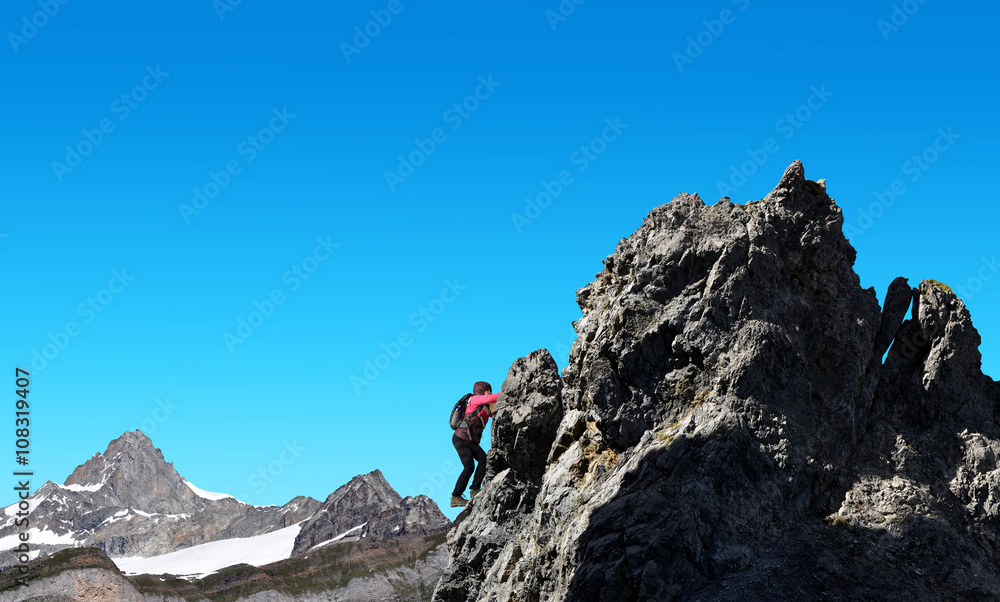 Hiker climbs on rock in the background mount Zinalrothorn - Pennine Alps, Switzerland